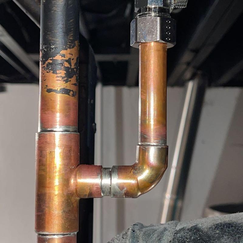 Copper gas line with elbow joint in basement ceiling