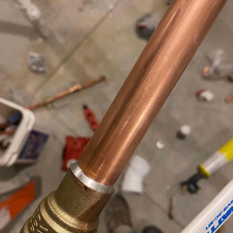 Copper gas line with brass fitting installation close-up