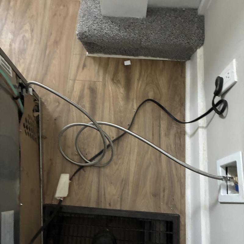 Stainless braided ice maker line installed behind refrigerator