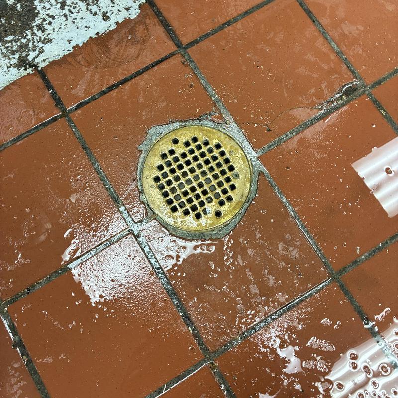 Kitchen floor drain with water on tiles