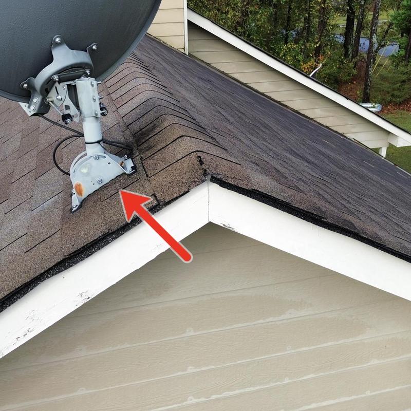 Roof shingles damaged near satellite dish base on slope