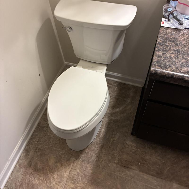 Toilet installation in corner bathroom near vanity