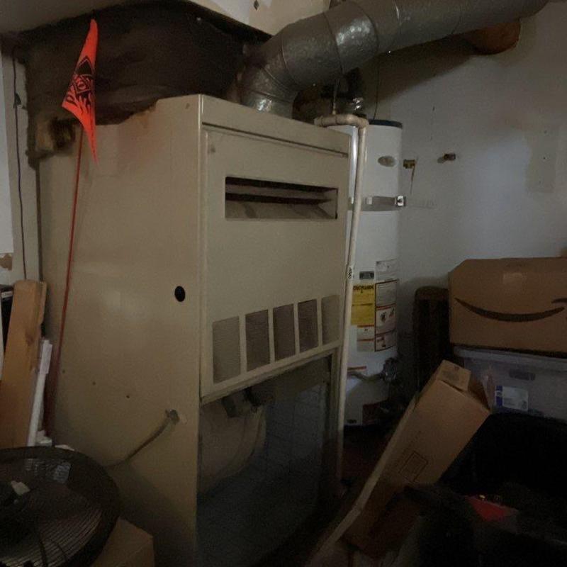 Furnace unit with ductwork and water heater nearby