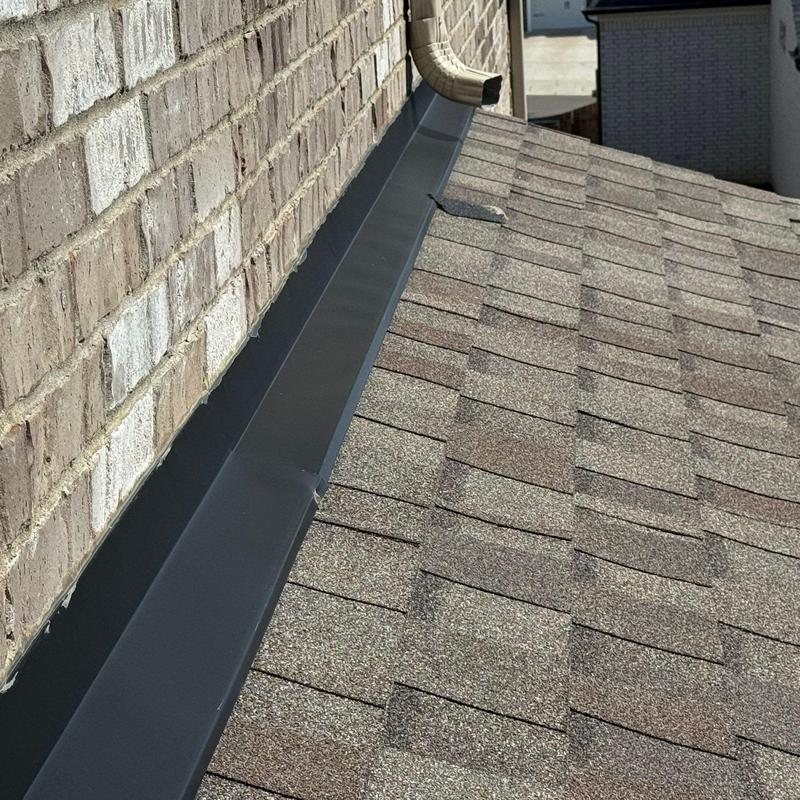 Roof flashing along brick wall with shingle roof