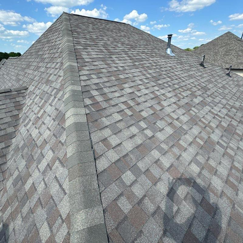 Asphalt shingle roof with ridge cap and vent pipes