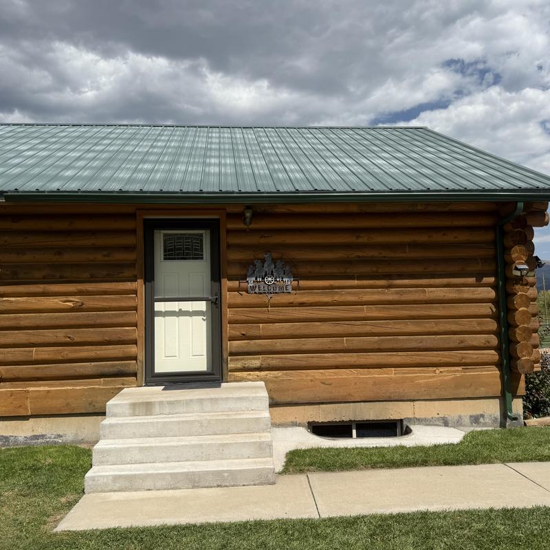 Metal roof on log cabin with entrance steps Metal roof on log cabin with entrance steps