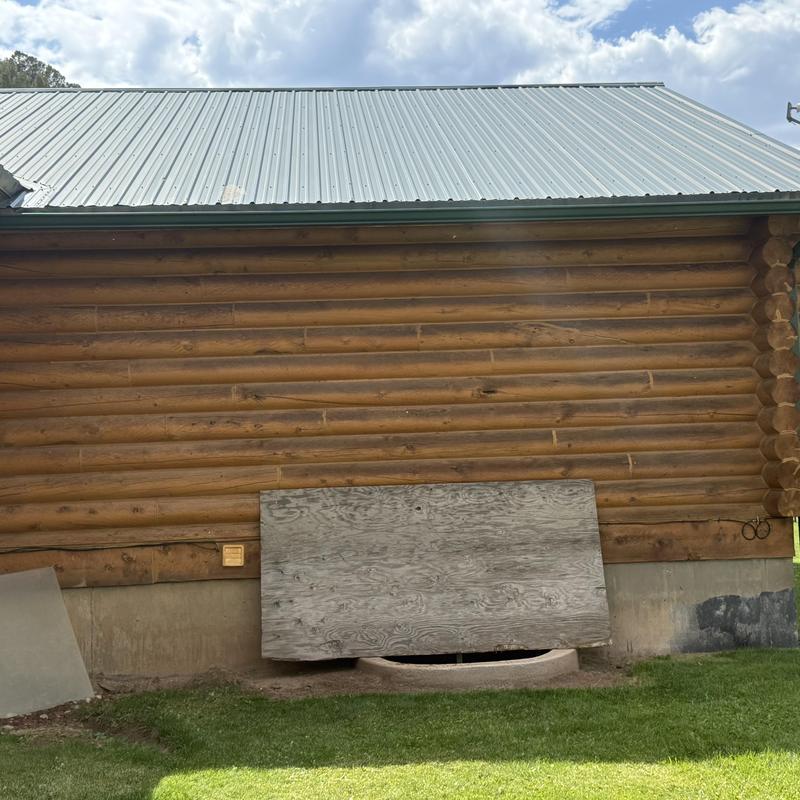 Basement egress window with wooden cover on log home Basement egress window with wooden cover on log home