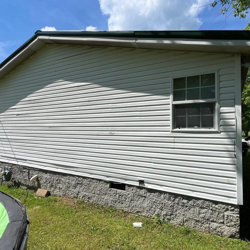 Vinyl siding damage on exterior wall with window