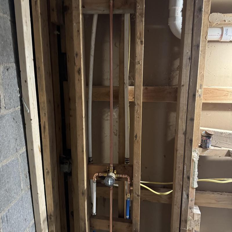 Copper water supply lines with pressure gauge in wall studs