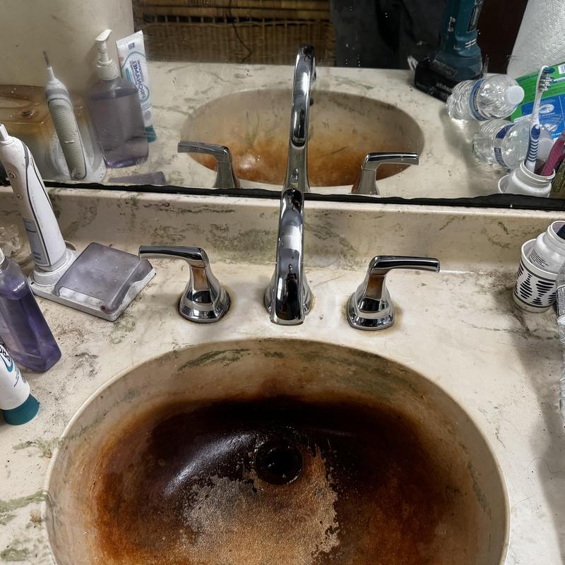 Bathroom sink with heavy rust and mineral stains