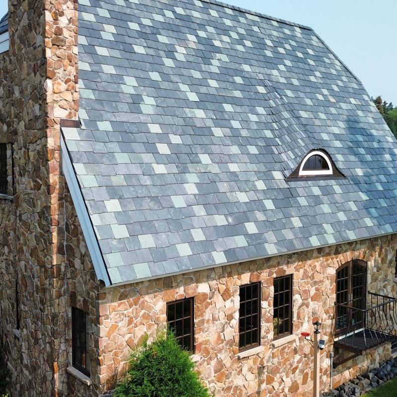 Synthetic slate roof with replaced damaged tiles