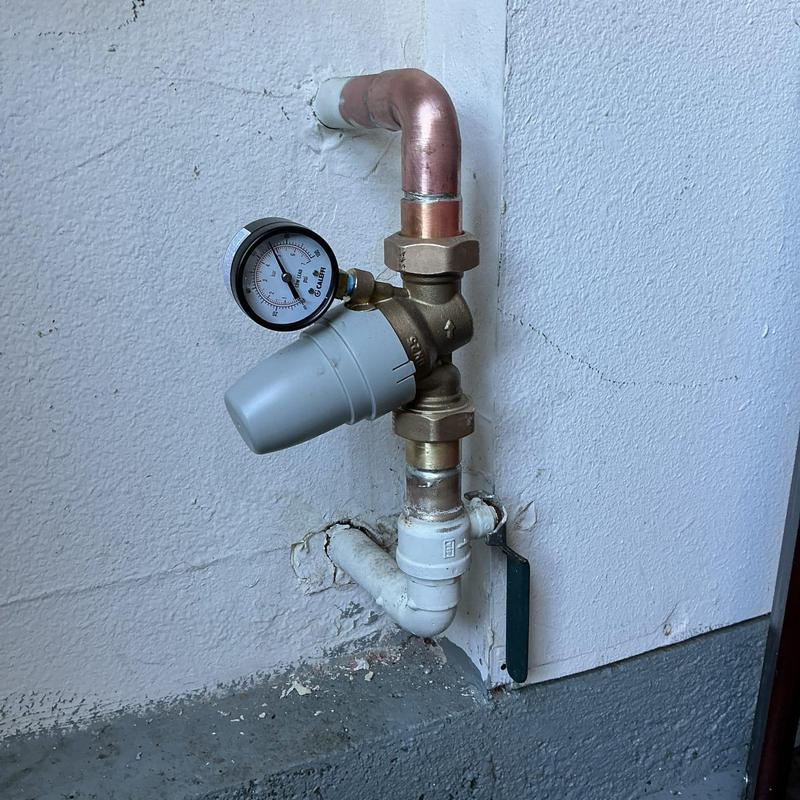 Water pressure regulator valve with gauge in garage