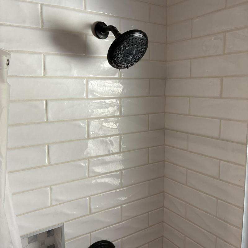 Shower head with restored water flow and clean tiles