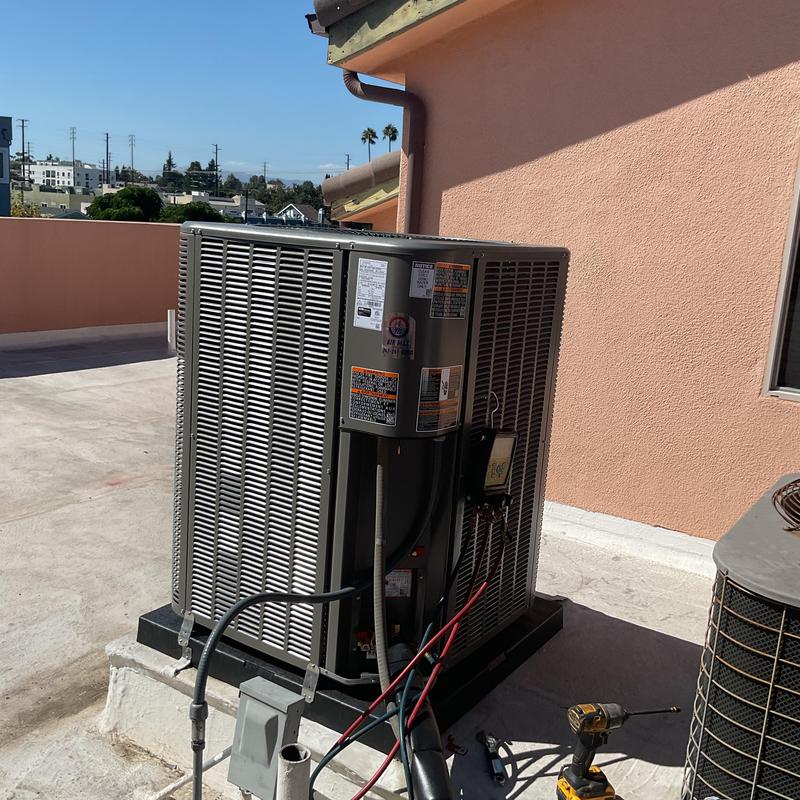 Heat pump unit installed on rooftop with tools nearby