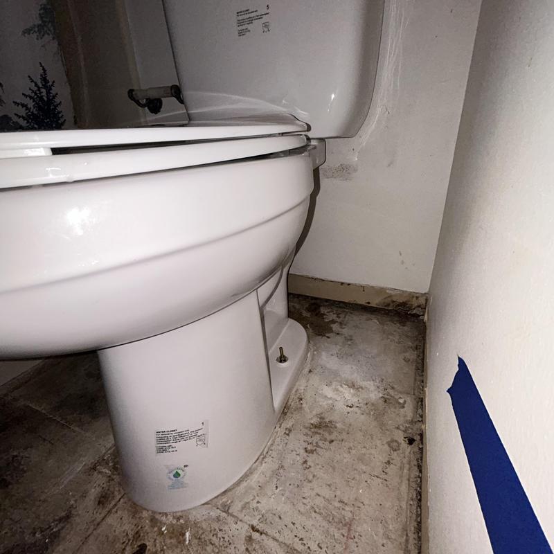 ADA toilet installation on tiled floor near wall