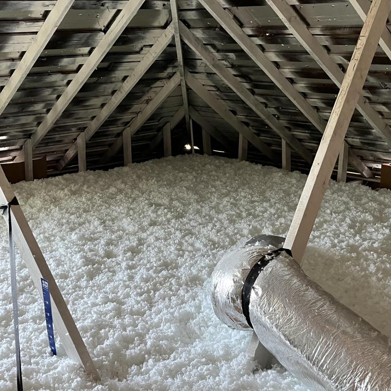 Attic insulation fully covering floor with ductwork visible