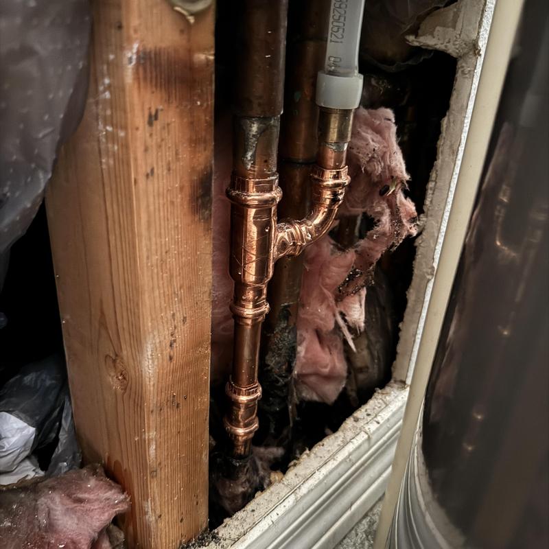 Copper hot water line with new fitting in wall cavity