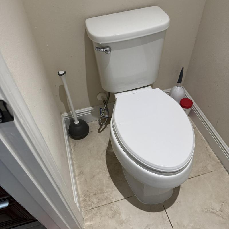 Toilet with new wax ring and grouted base in bathroom