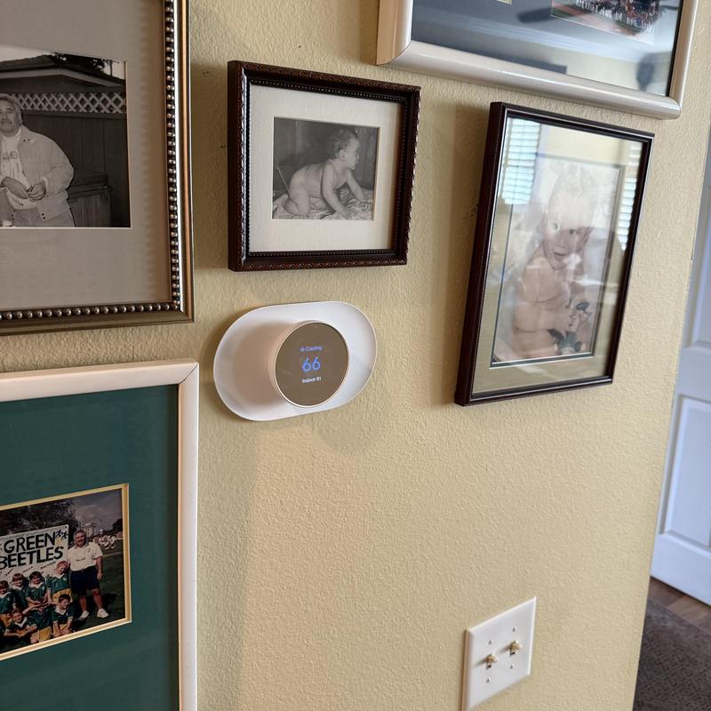 Thermostat display set to 66 degrees on beige wall