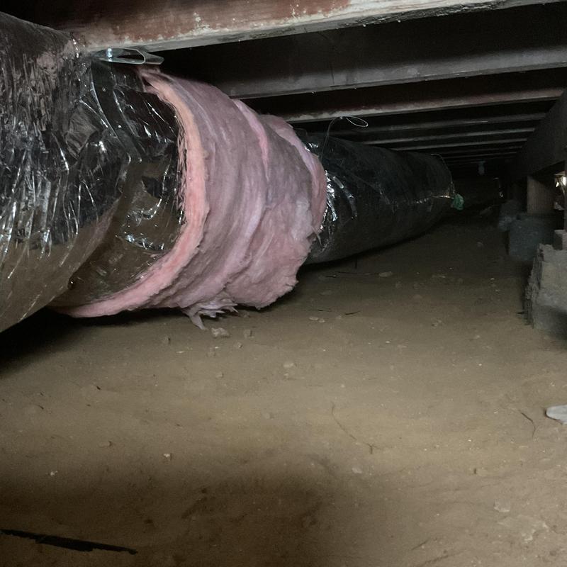 Ductwork with pink insulation in crawl space