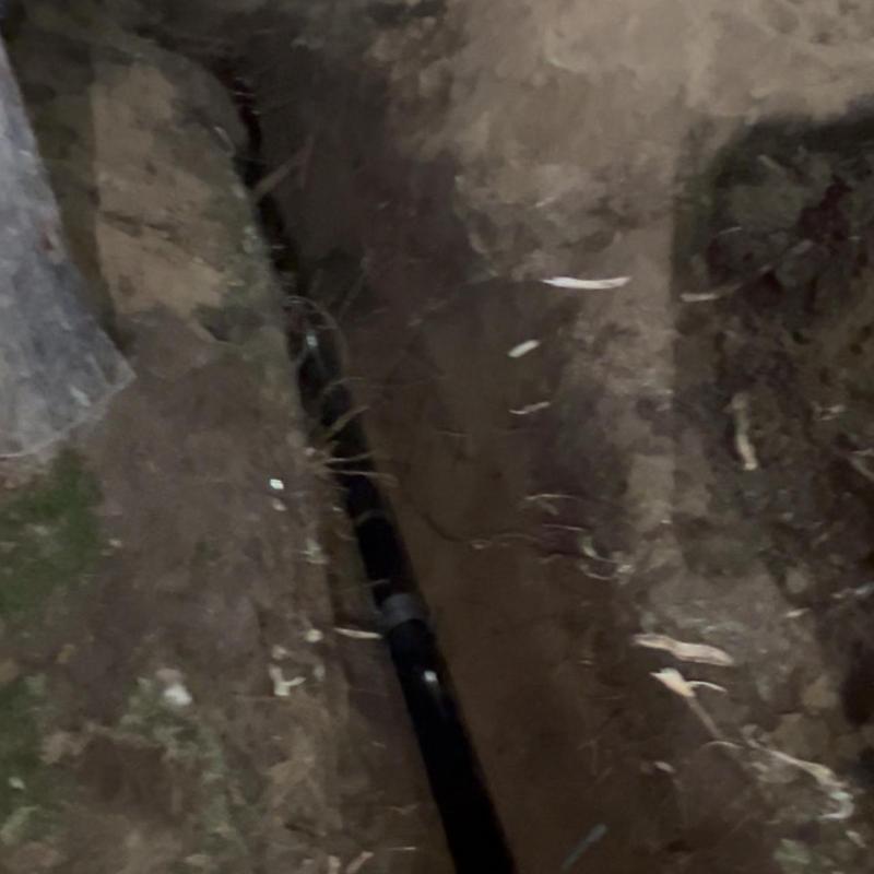 New sewer pipe installation in trench at night