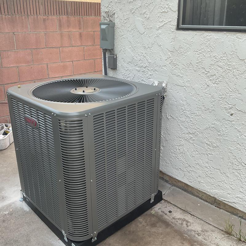 Condenser unit installed on concrete pad outdoors