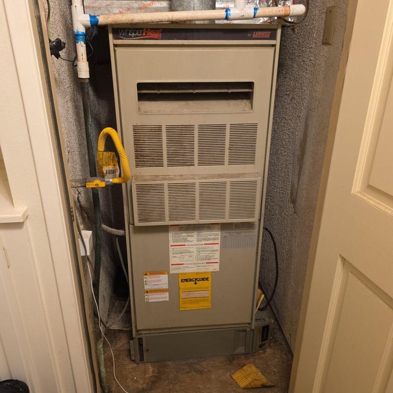 Furnace unit in utility closet with piping and wiring