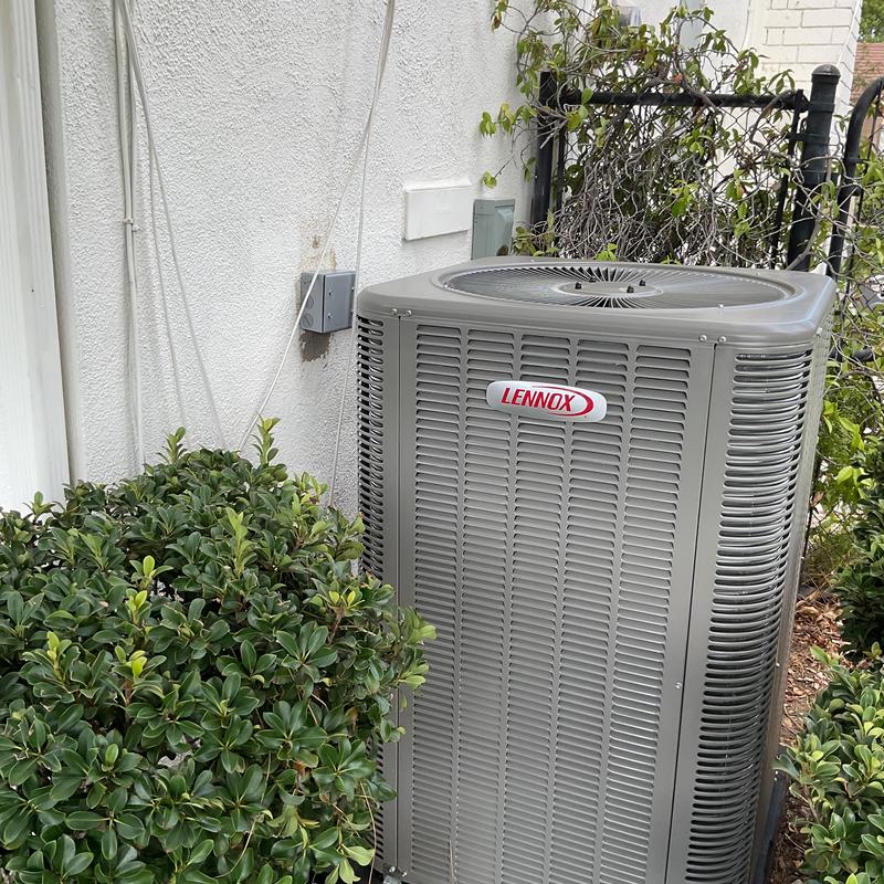 Lennox ML14KC1 condenser unit outdoors near bushes