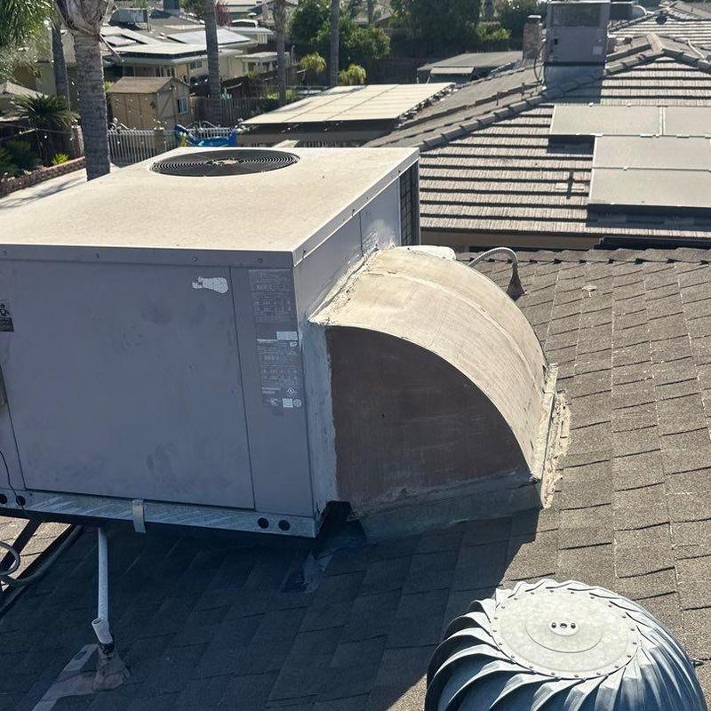 Package unit on shingled roof with ductwork