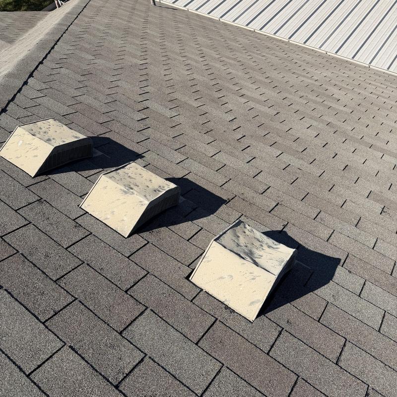 Asphalt shingle roof with hail damage on vents