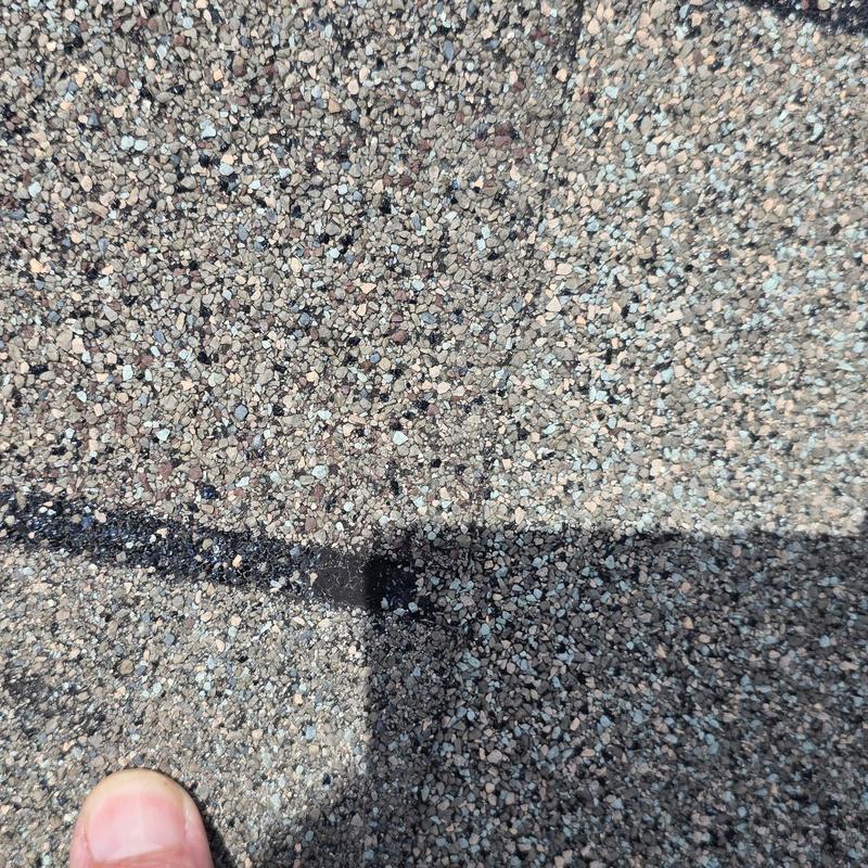 Asphalt roofing shingles with hail damage close-up