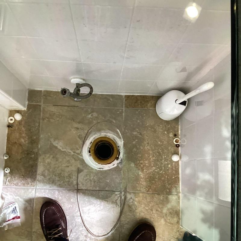 Toilet flange installation with wax ring on tile floor