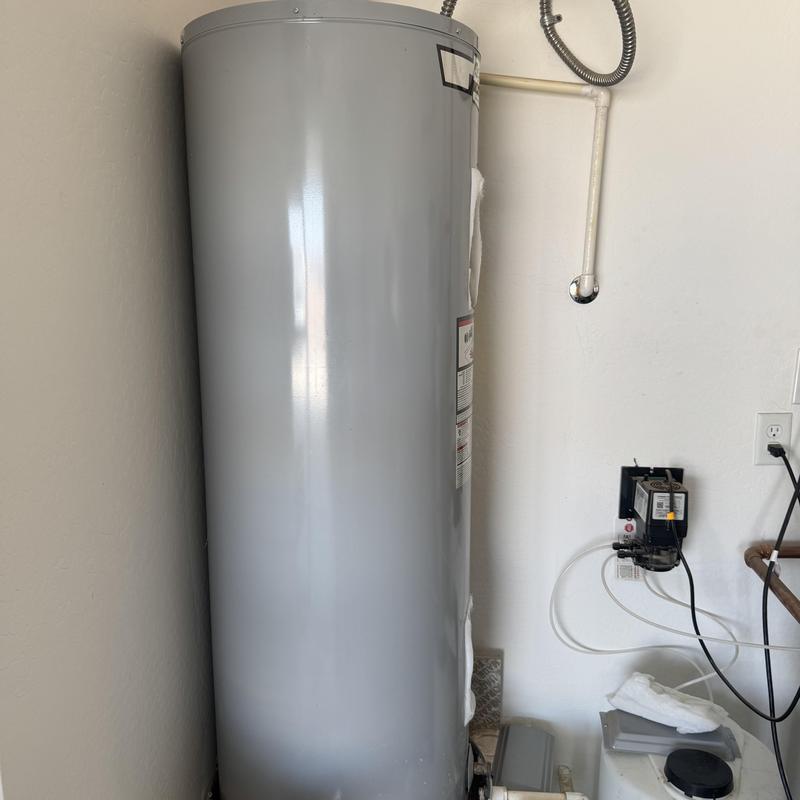 Water heater tank with connected pipes and controls