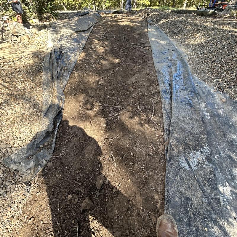 Water service pipe trench excavation with protective fabric lining