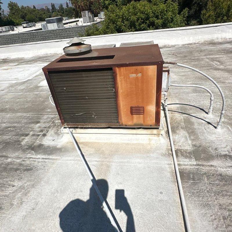 Old rooftop HVAC package unit on flat roof