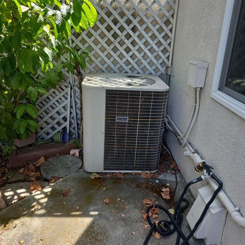 Heat pump unit installed by house exterior wall Heat pump unit installed by house exterior wall
