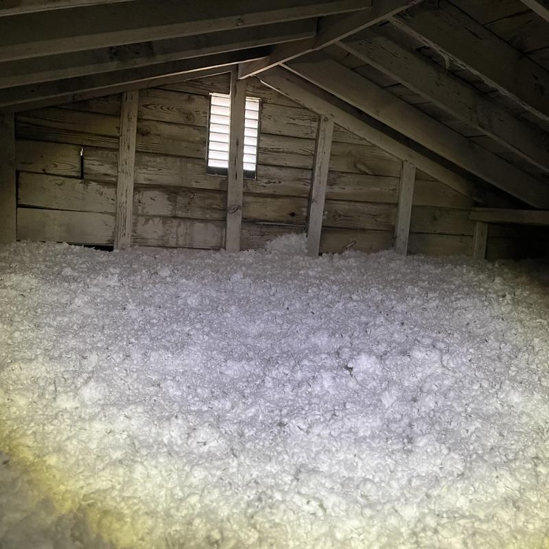 Attic blown-in insulation installation in wooden attic