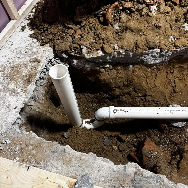 PVC shower drain piping installation in floor trench
