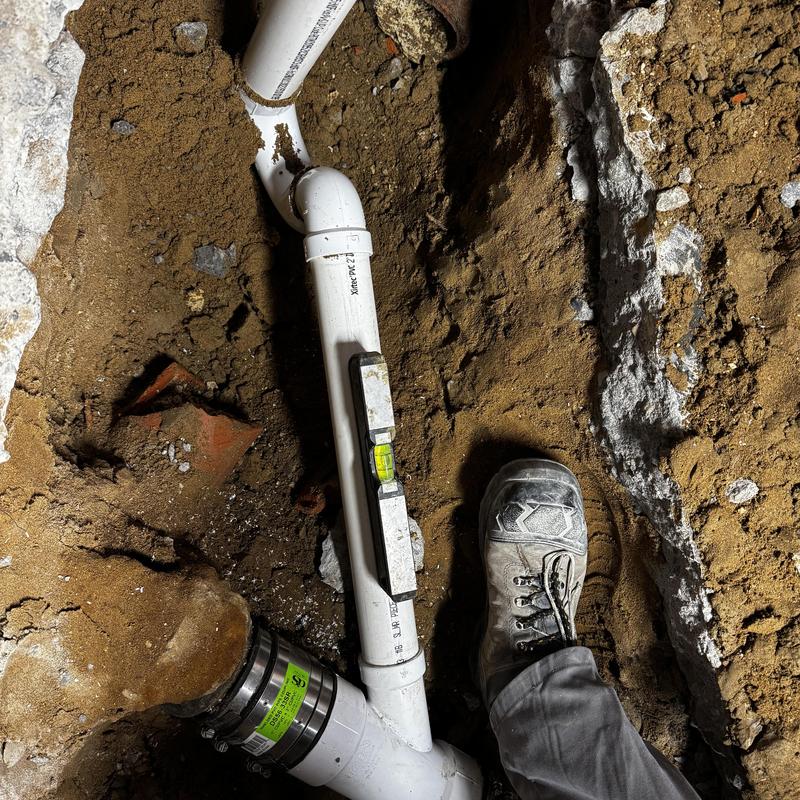 Shower drain PVC piping tied into cast iron sewer line