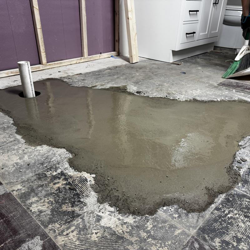 Shower drain pipe with fresh concrete floor patch