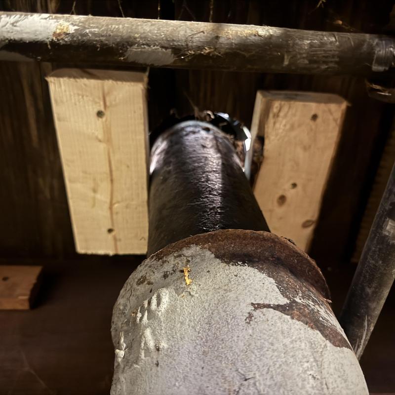 Cast iron toilet flange installed on floor joists