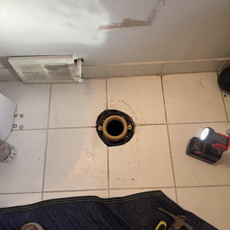 Toilet flange mounted in bathroom floor tiles