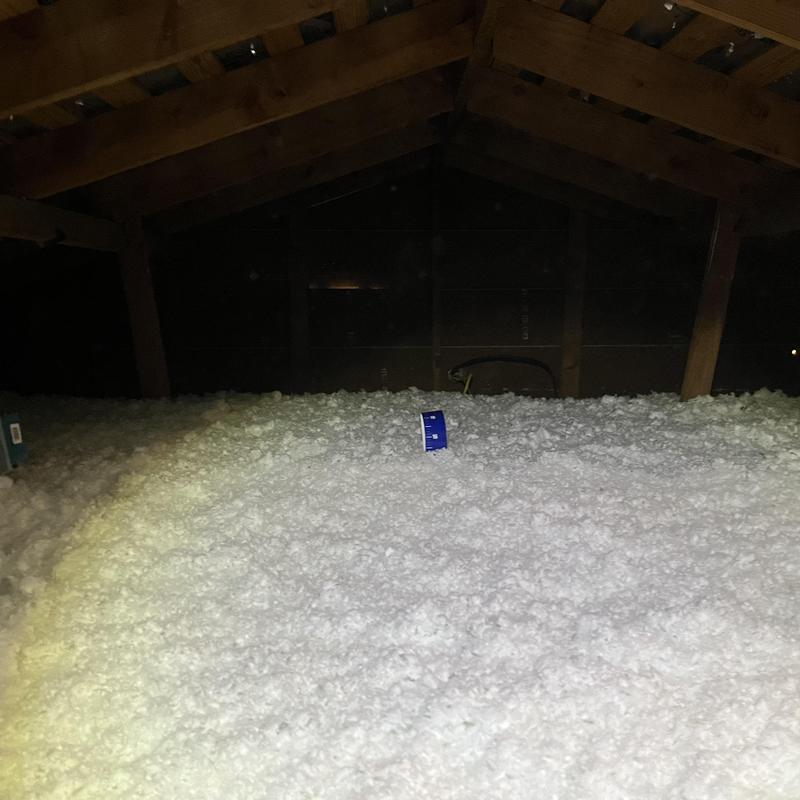 Attic loose-fill insulation installed under roof beams