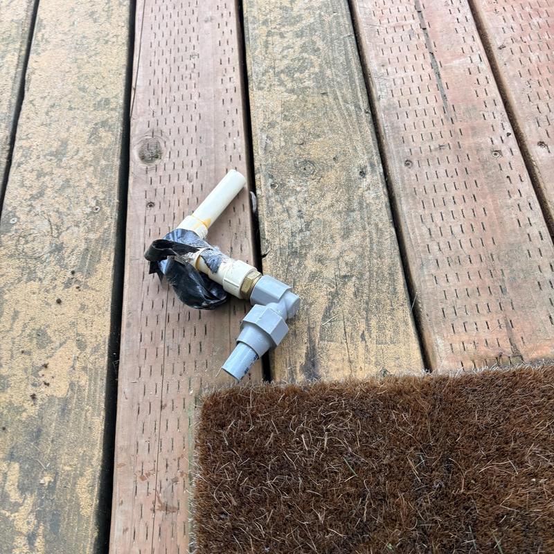PVC pipe elbow fitting on wooden deck near mat