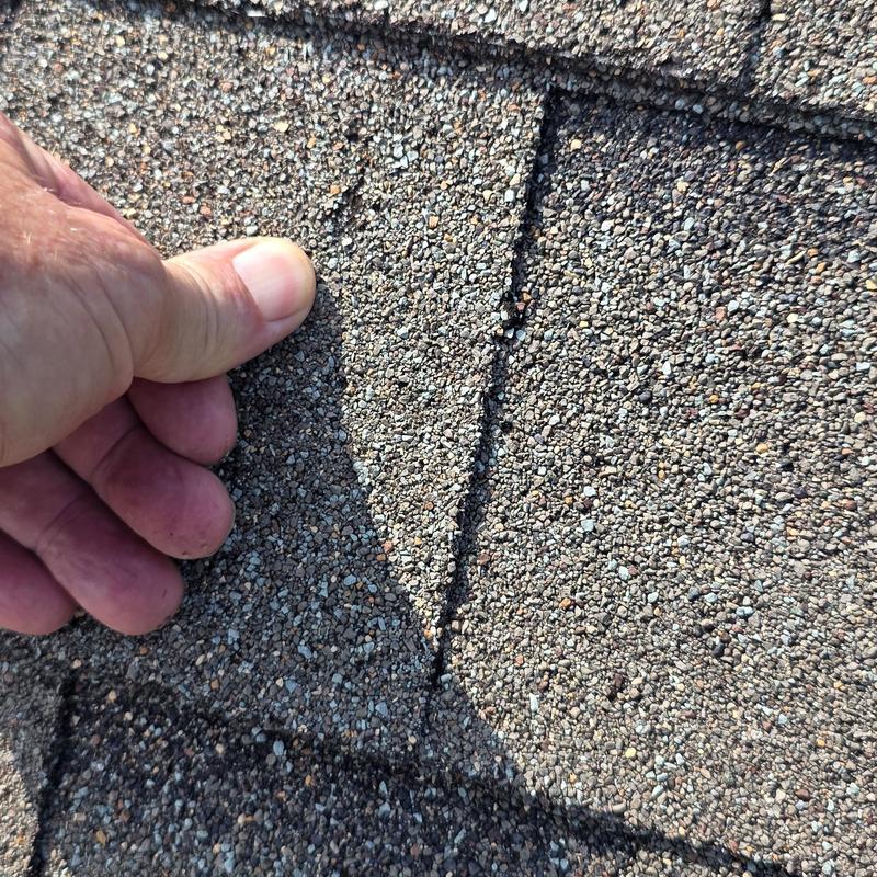 Asphalt shingle roof with hail damage close-up