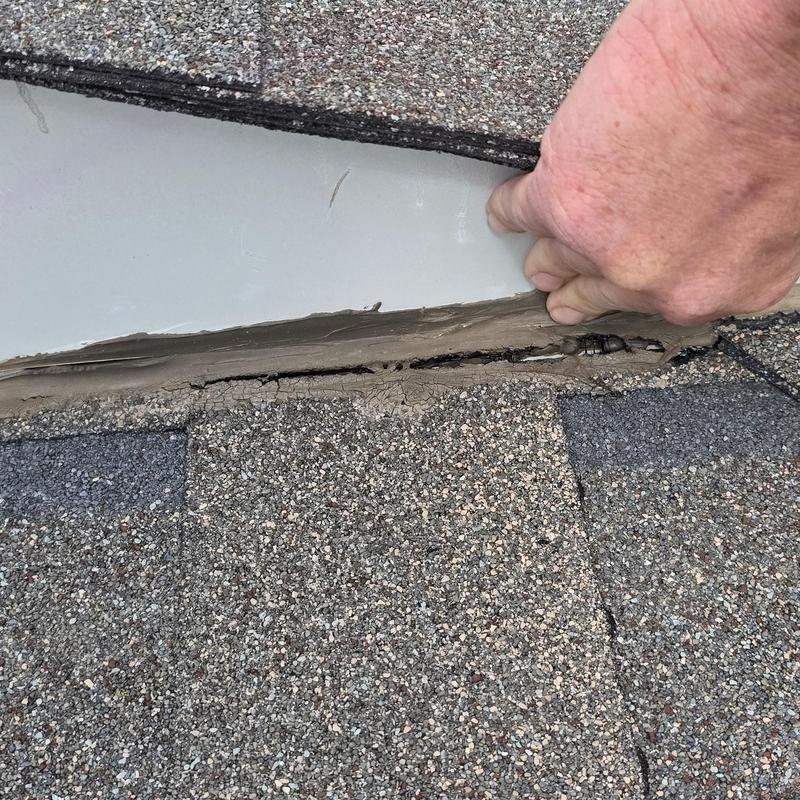Roof flashing with cracked sealant inspection and hand check