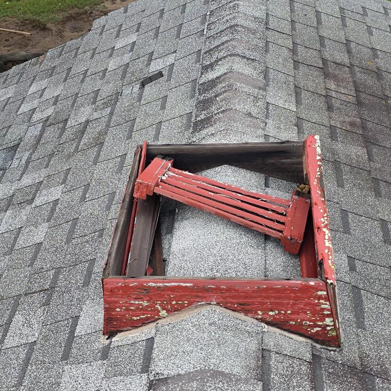 Roof shingles with damaged red wooden roof vent frame Roof shingles with damaged red wooden roof vent frame