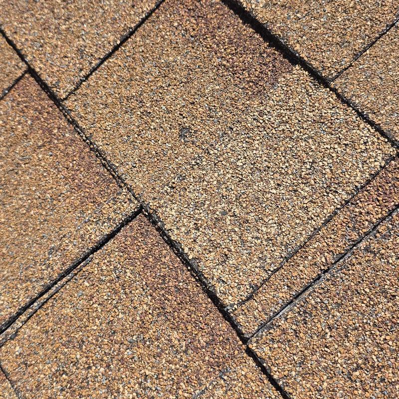 Asphalt roof shingles close-up with hail impact marks