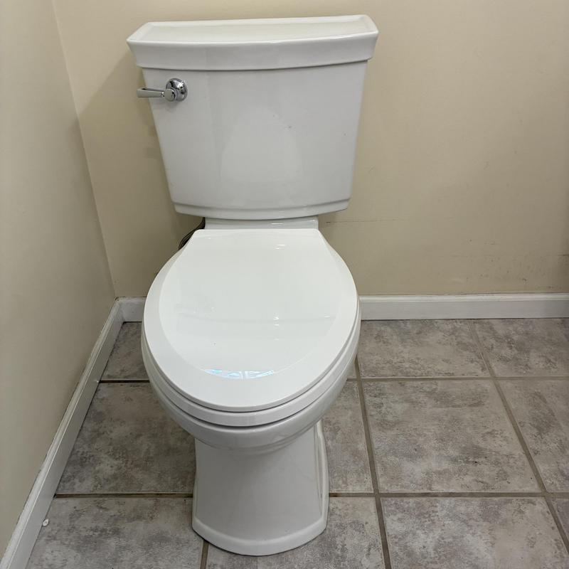Toilet installation in corner bathroom with tile floor