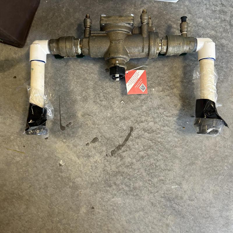 Backflow prevention device with wrapped pipe ends